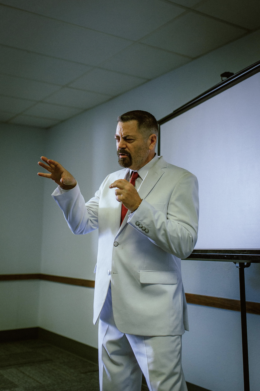 man in white suit with red tie give lecture in Sovereign