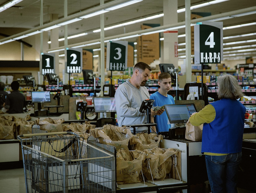 father, son, and check-out lady in grocery store in Sovereign
