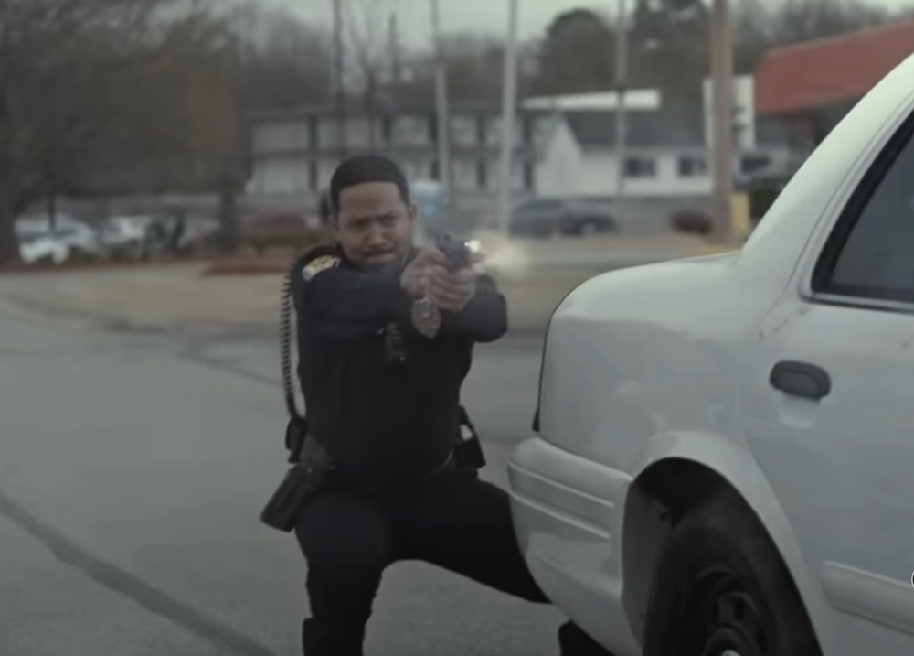 Police officer fires from behind cruiser in Sovereign.