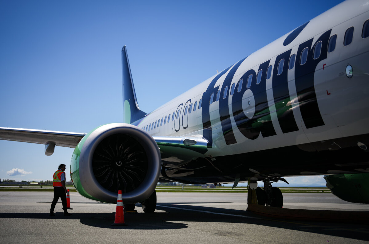 Flair Airlines captain Ken Symonds inspects the outside of one of the company's Boeing 737 MAX 8 aircraft while parked at a gate at Vancouver International Airport, in Richmond, B.C., on April 17, 2024. (The Canadian Press/Darryl Dyck)
