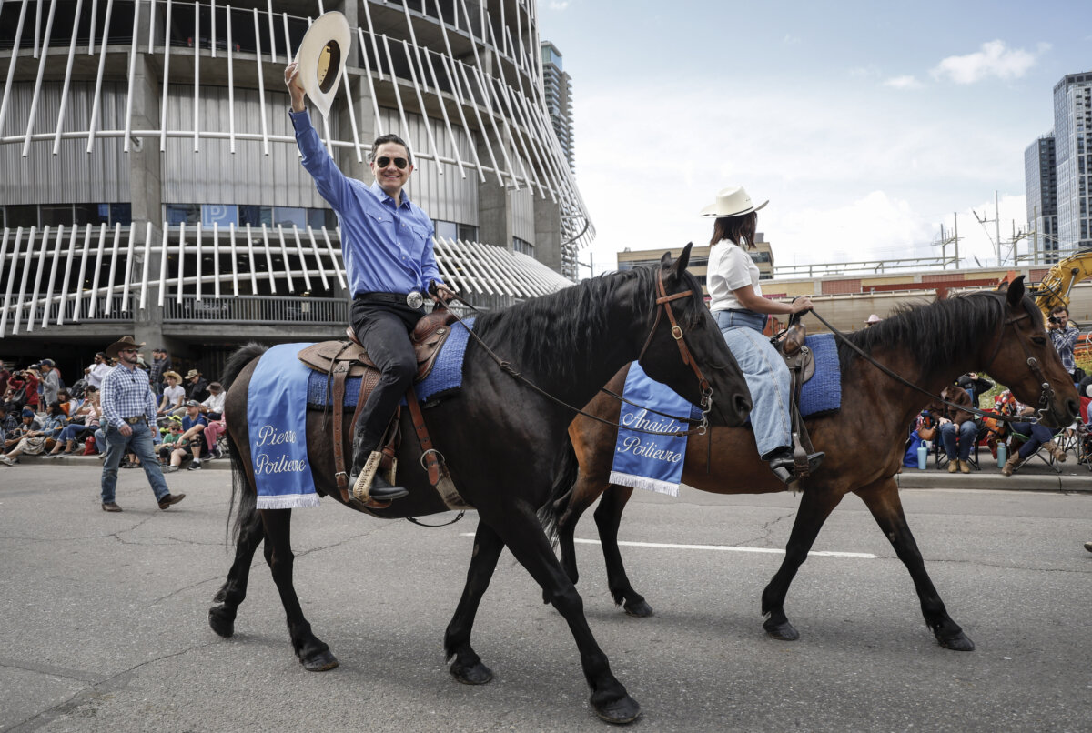 Conservative Leader Pierre Poilievre waves to the crowd as he rides in the Calgary Stampede parade in Calgary on July 4, 2025. (THE CANADIAN PRESS/Jeff McIntosh)