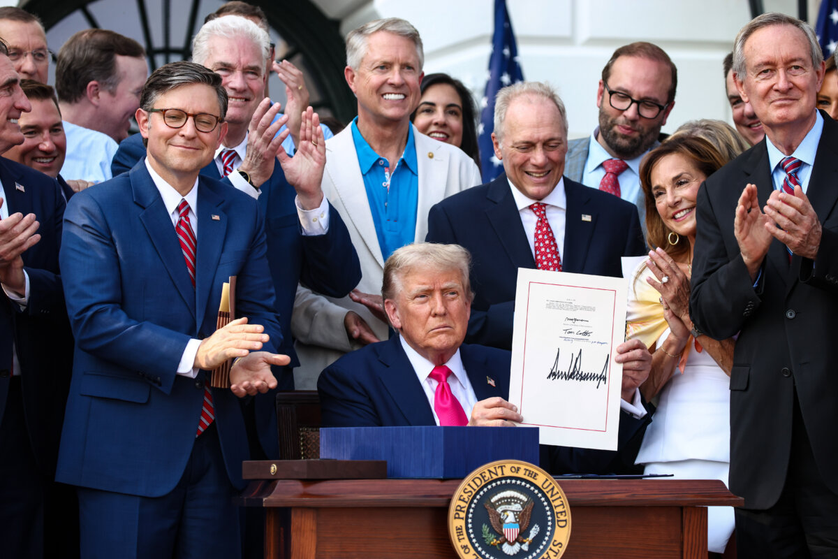President Donald Trump, joined by Republican lawmakers, signs the One, Big Beautiful Bill Act into law during an Independence Day military family picnic on the South Lawn of the White House on July 04, 2025. (Samuel Corum/Getty Images)