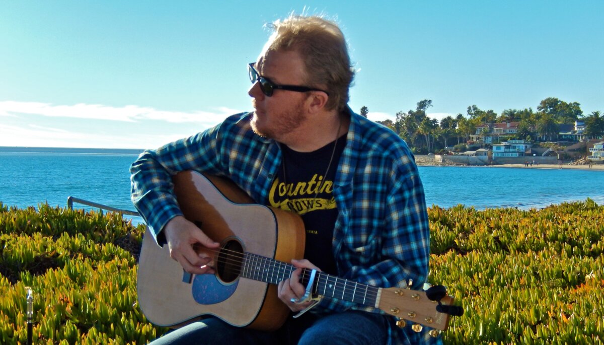 Chris Ahlman plays the guitar at the beach. Ahlman stated on his website, “My music is focused towards inspiring people to think about life ... and the world that we live in from a positive and good perspective.” (Courtesy of Chris Ahlman)