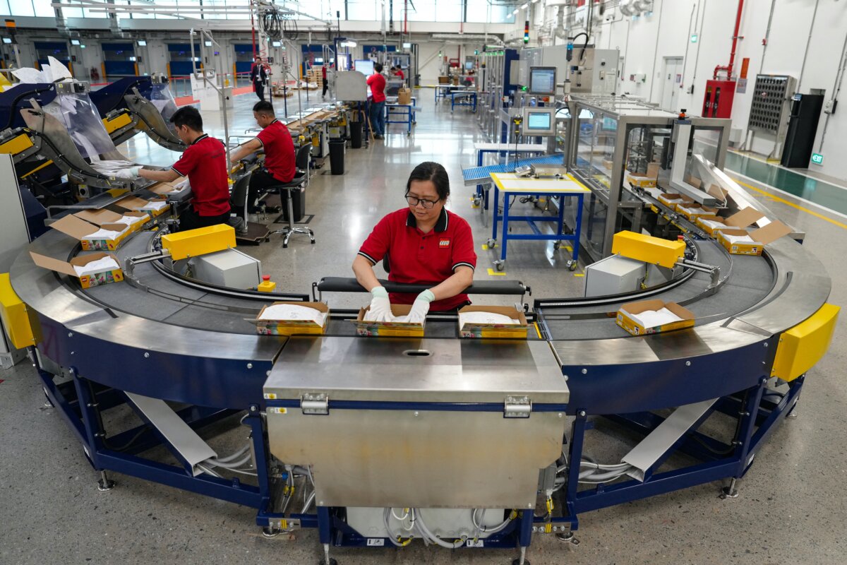 Employees prepare Lego packages on a production-line during the inauguration of the Lego factory in Binh Duong Province, Vietnam, on April 9, 2025. (STR/AFP via Getty Images)