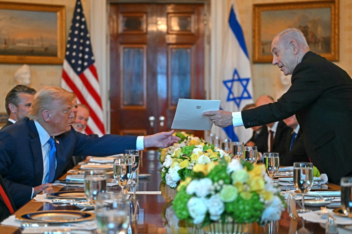 Israeli Prime Minister Benjamin Netanyahu (R) hands a letter to U.S. President Donald Trump as they meet in the Blue Room of the White House on July 7, 2025. (Andrew Caballero-Reynolds/AFP)