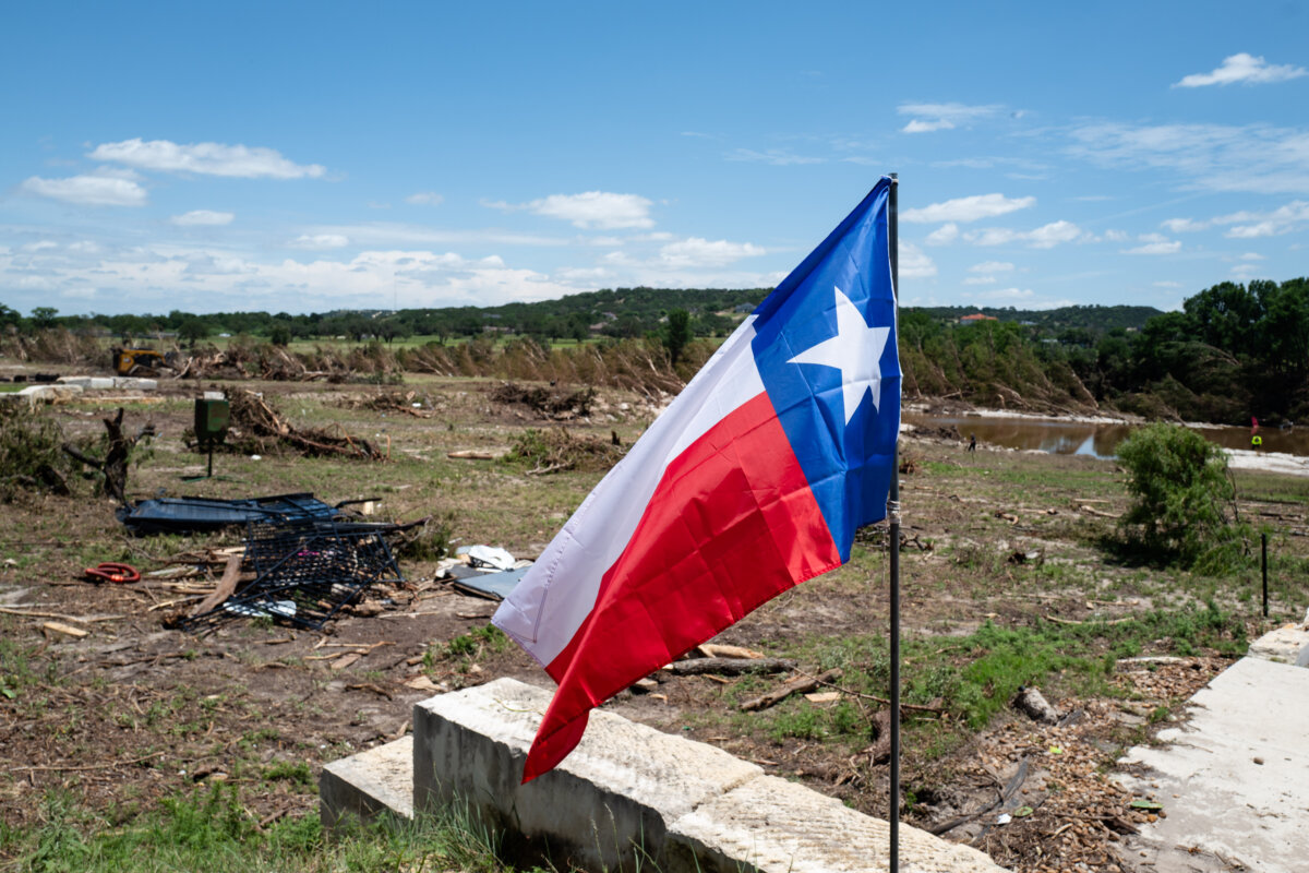 The Texas flag at a house next to the Guadalupe River in the aftermath of flash floods in Kerrville, Texas, on July 8, 2025. (Madalina Kilroy/The Epoch Times)