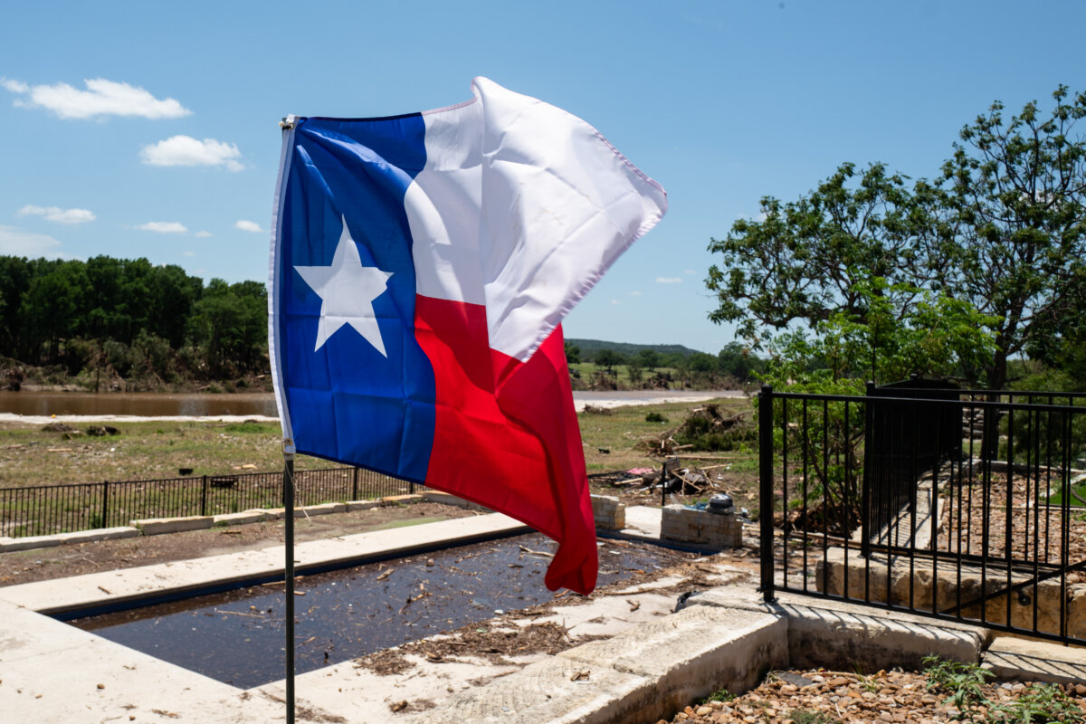 A Texas flag at a house next to the Guadalupe River in the aftermath of flash floods in Kerrville, Texas, on July 8, 2025. (Madalina Kilroy/The Epoch Times)