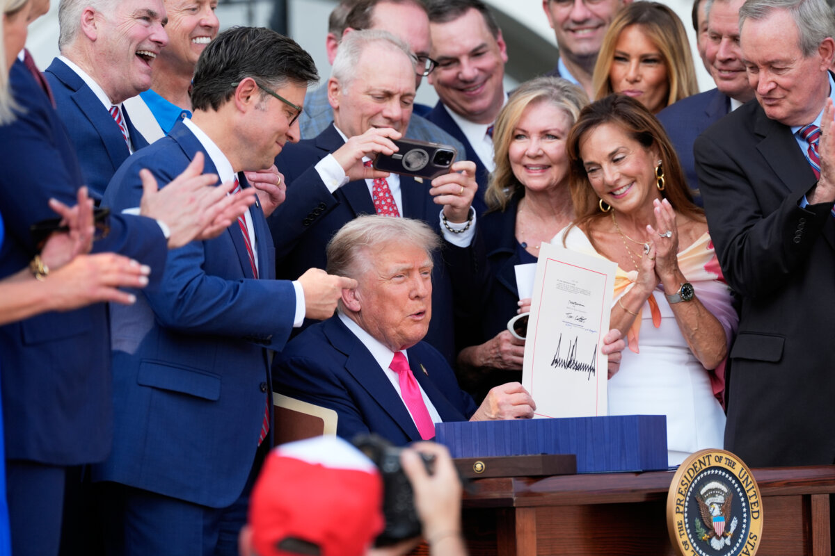 President Donald Trump holds up the "One, Big Beautiful Bill" Act that was signed into law during an Independence Day military family picnic on the South Lawn of the White House on July 4, 2025. (Alex Brandon/Pool/Getty Images)