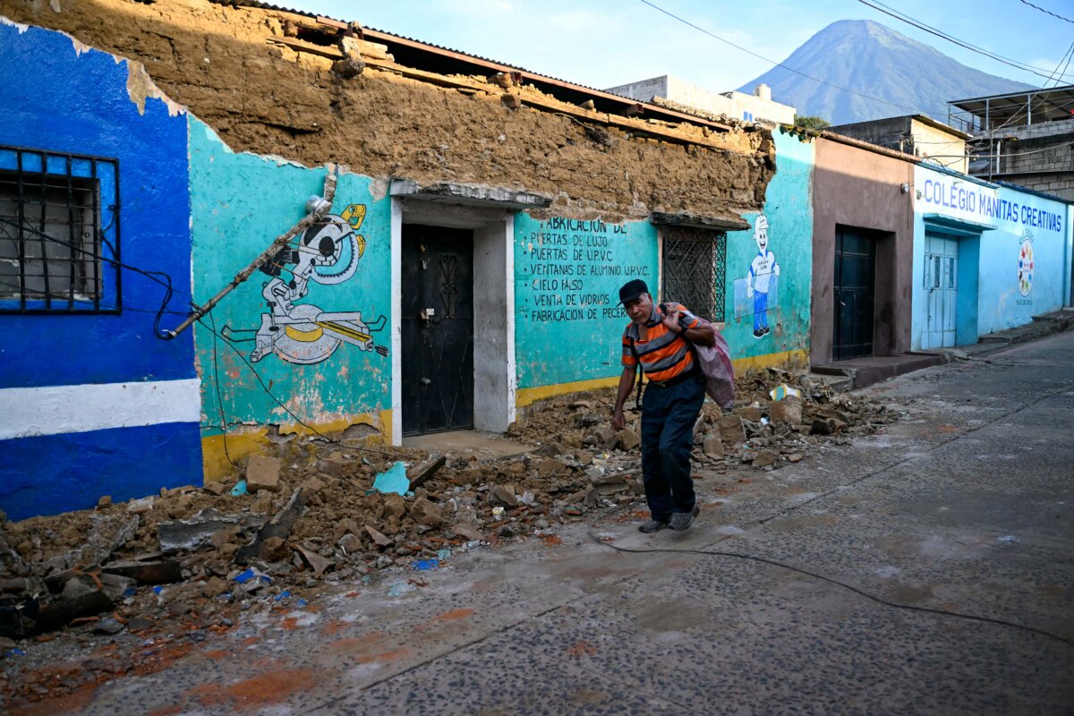 A man walks past the collapsed wall of a store after a series of earthquakes rattled the area in Palin, Guatemala, on July 9, 2025. Two people were killed when their vehicle was buried under a landslide after a series of earthquakes shook much of the Central American country on Tuesday, authorities said. (Johan Ordonez/AFP via Getty Images)