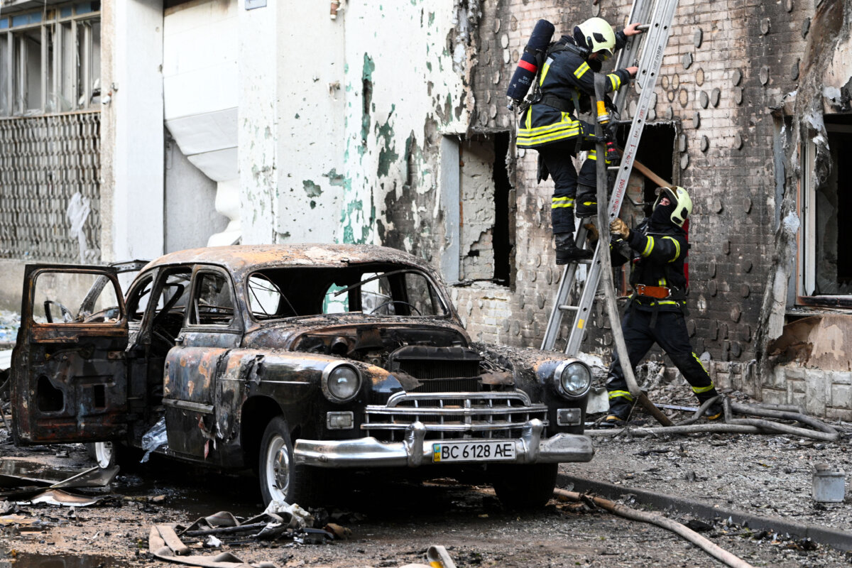 Firefighters work next to a burnt-out car following mass Russian drone and missile strikes in the western Ukrainian city of Lviv on July 12, 2025. (Yuriy Dyachyshyn/AFP via Getty Images)