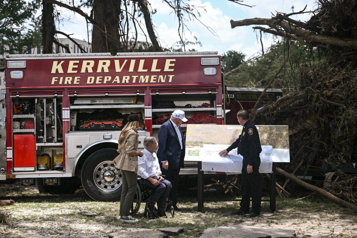 President Donald Trump, Texas Gov. Greg Abbott (2nd L), and First Lady Melania Trump (L) meet with local officials and first responders near the Guadalupe River following devastating flooding that occurred in the area over the July 4 weekend, in Kerrville, Texas, on July 11, 2025. (Brendan Smialowski/AFP via Getty Images)