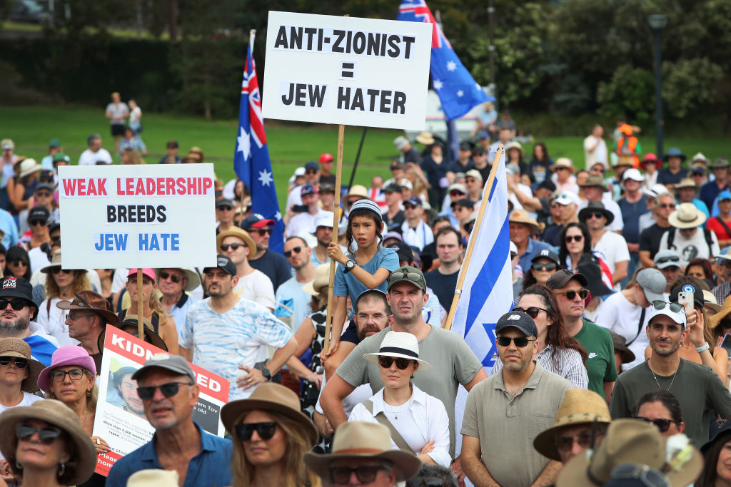Protestors hold placards and flags during a rally against antisemitism at The Domain on February 18, 2024 in Sydney, Australia. In response to a nearly 738% surge in reported antisemitic incidents in Australia, The Never Again Is Now movement is mobilising a huge number of people across Australia, kicking off in Sydney, with an estimated 10,000 people in attendance, organisers said. (Photo by Lisa Maree Williams/Getty Images)
