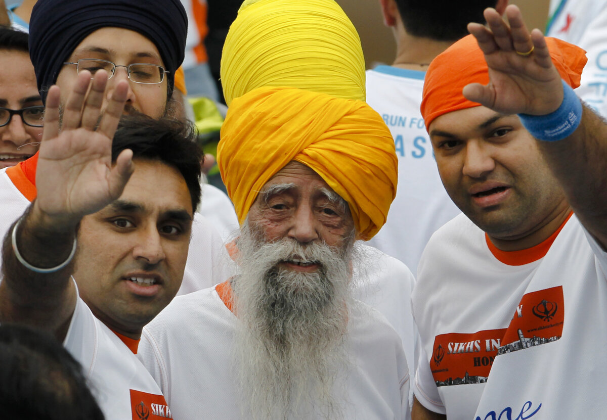 Centenarian marathon runner Fauja Singh (C) smiles after finishing a 10-kilometer race, held as part of the annual Hong Kong Marathon, in Hong Kong on Feb. 24, 2013. (Vincent Yu/AP Photo)