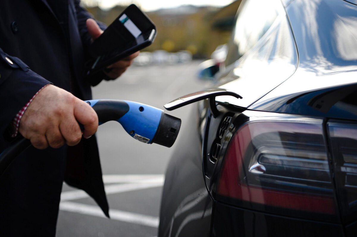 A customer prepares to charge his Tesla electric vehicle (EV) in a bay for electric vehicles at a supermarket in north London on Nov. 18, 2020. (Daniel Leal-Olivas /AFP via Getty Images)