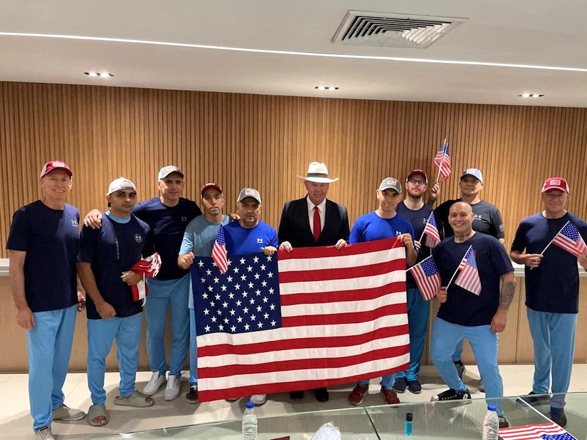 U.S. citizens released from Venezuela pose for a photo holding U.S. flags after a prisoner swap, at an unknown location, in this handout picture released on July 18, 2025. (Venezuela's U.S. Embassy/Handout via Reuters)