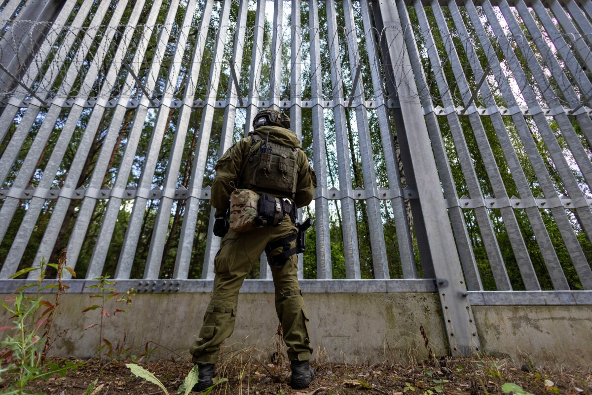 A Polish border guard officer stands at the Polish-Belarusian border in front of the border fence in Polowce-Pieszczatka, Poland, on July 21, 2025. (Photo by Wojtek Radwanski/AFP via Getty Images)