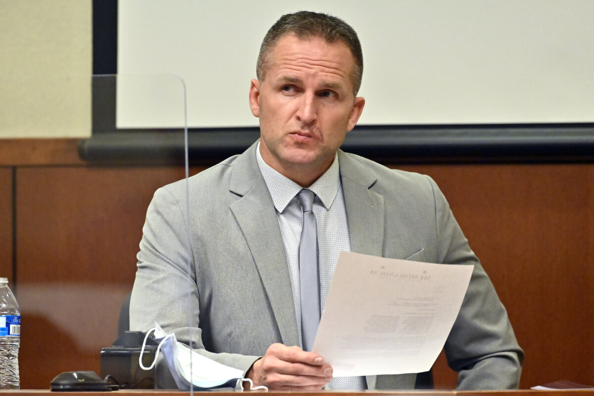 Former Louisville Police officer Brett Hankison examines a document as he answers questions from the prosecution, in Louisville, Ky., on March 2, 2022. (Timothy D. Easley/Pool via AP Photo)