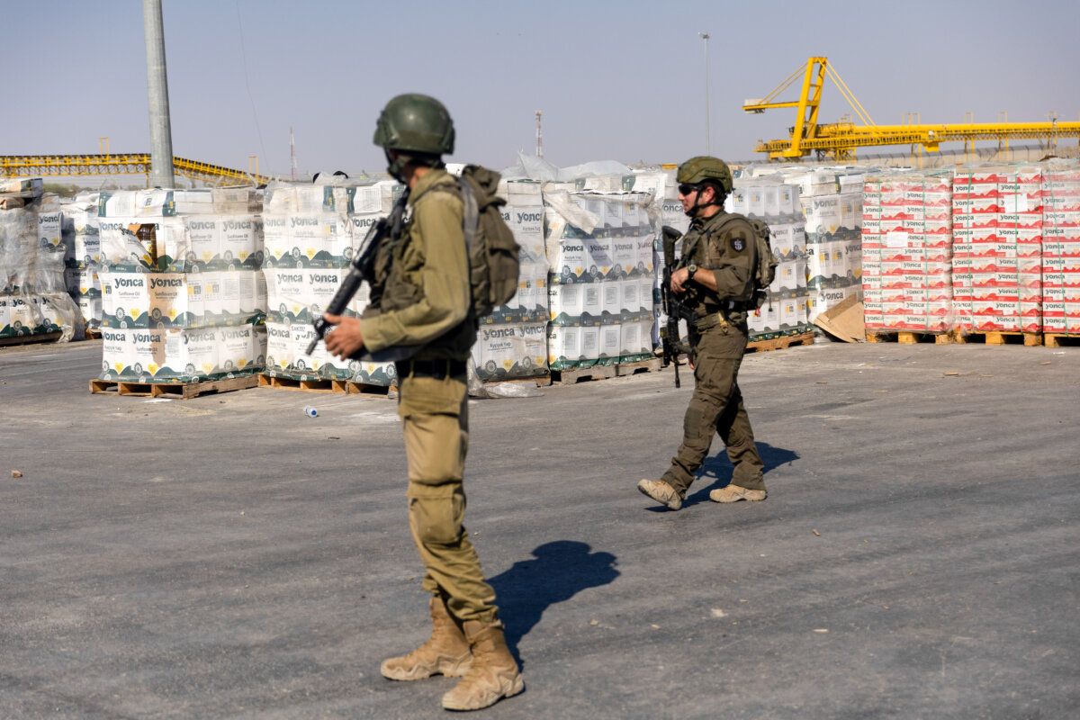 Israeli soldiers pass by humanitarian aid packages waiting to be picked up on the Palestinian side of the Kerem Shalom Crossing Point in Kerem Shalom, Gaza Strip, on July 24, 2025. (Photo by Amir Levy/Getty Images)