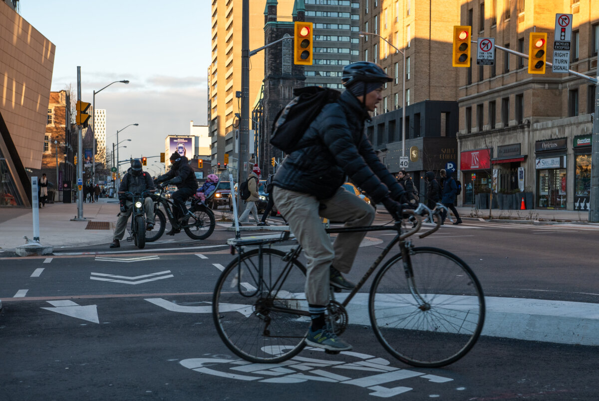 Cyclists ride in a bike lane at St. George St. and Bloor St. West in Toronto on Dec. 13, 2024. (The Canadian Press/Laura Proctor)