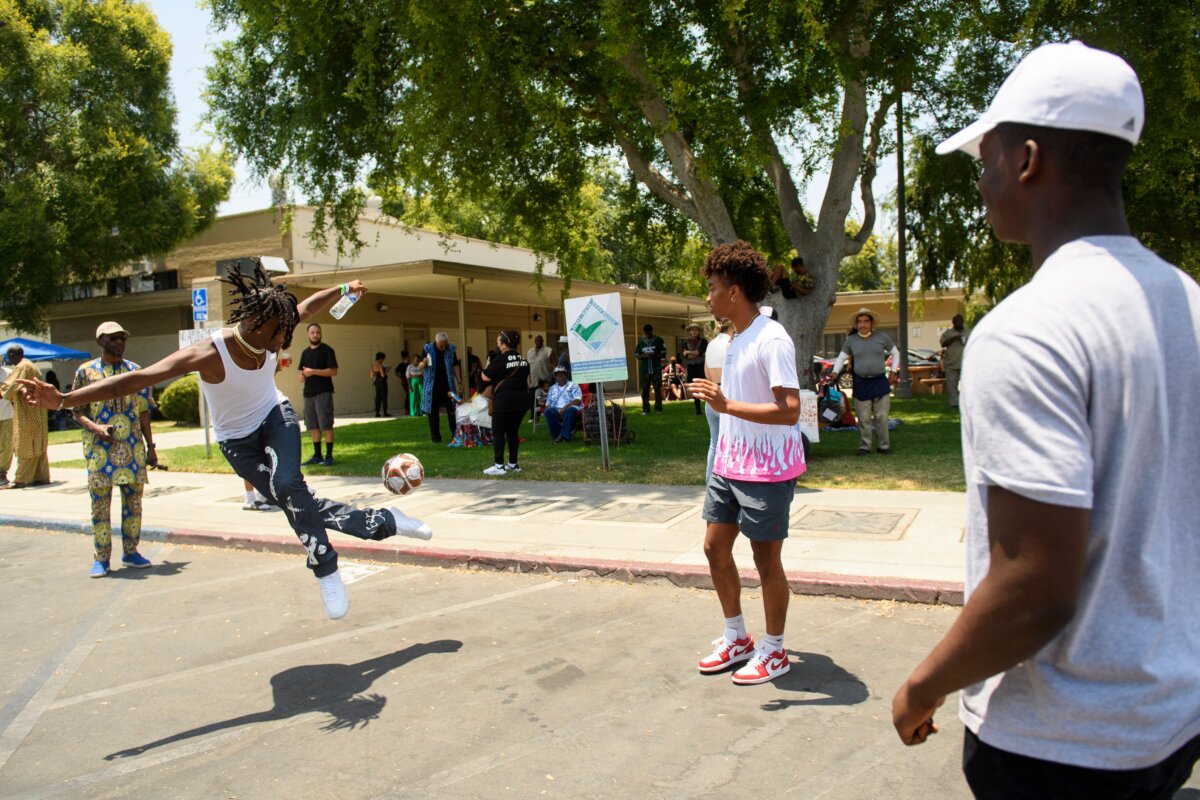 People play with a soccer ball during the Watts Juneteenth Street Fair in the Watts neighborhood of Los Angeles, on June 19, 2021. (Patrick T. Fallon/AFP via Getty Images)