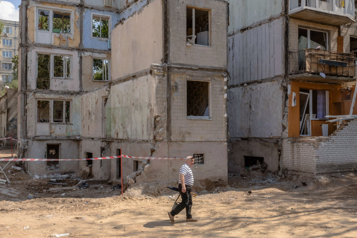 A man walks past a nine-story residential building destroyed following a recent Russian missile strike in Kyiv, amid the Russian invasion of Ukraine, on Aug. 5, 2025. (Photo by ROMAN PILIPEY/AFP via Getty Images)