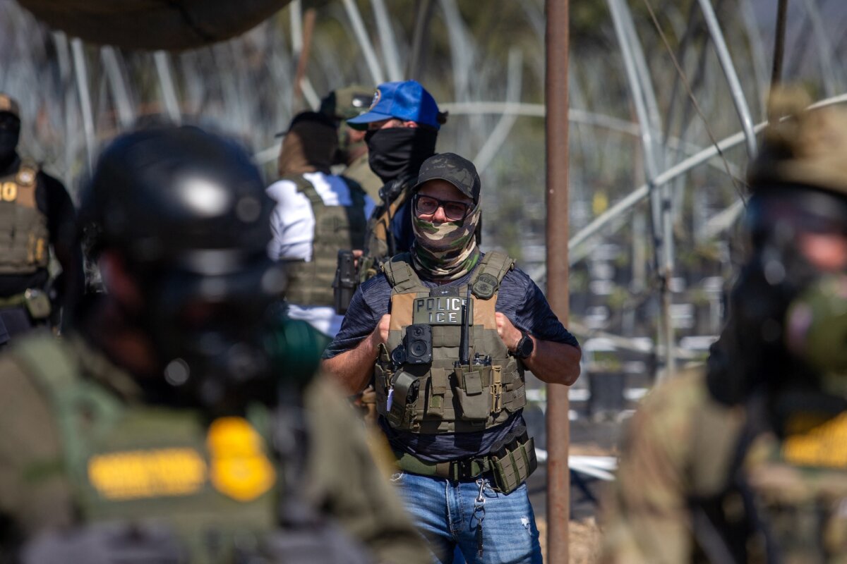 A U.S. Immigration and Customs Enforcement agent watches as Customs and Border Protection officers confront protesters in Camarillo, Calif., on July 10, 2025. (Blake Fagan/AFP/Getty Images)