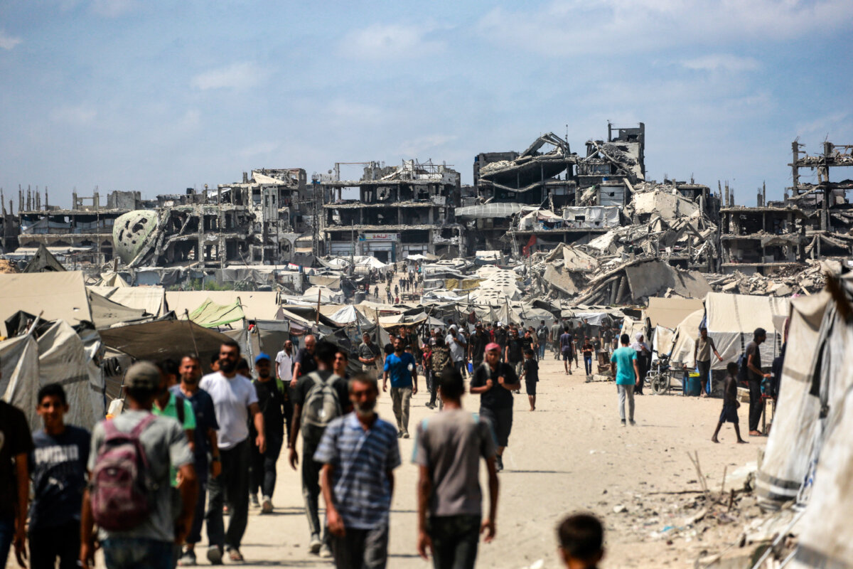 Palestinians walk along a street near war-damaged buildings in Gaza City on Aug. 8, 2025. (Bashar Taleb/AFP via Getty Images)