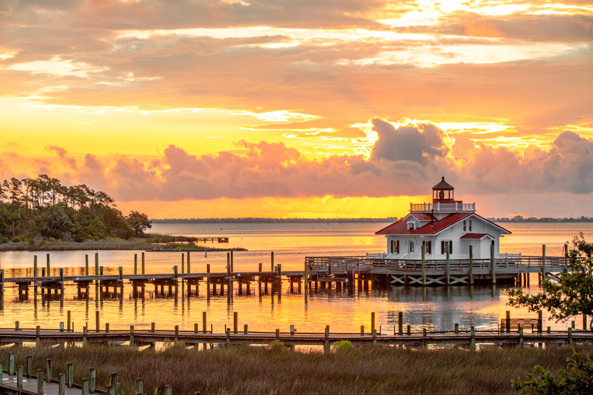 Roanoke Marshes Lighthouse with a beautiful orange and yellow sky in the background. (Courtesy of VisitNC.com)