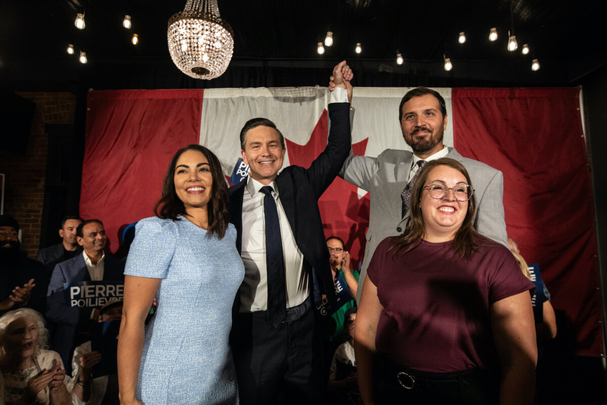 Conservative Leader Pierre Poilievre and his wife Anaida Poilievre (L) celebrate with former Conservative MP Damien Kurek and his wife Danielle Kurek during the Battle River-Crowfoot byelection in Camrose, Alta., on Aug. 18, 2025. (The Canadian Press/Jason Franson)
