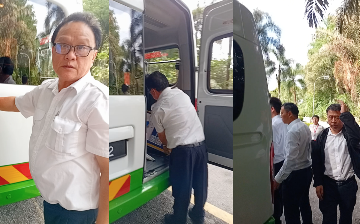 Individuals caught on camera leaving by a tour bus after seizing display boards from a Falun Gong booth in Kuala Lumpur, Malaysia, on Aug. 15, 2025. (Screenshot by The Epoch Times)