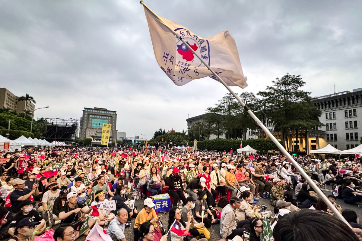 People wave flags and cheer at a “Reject United Front Work, Protect Taiwan” rally on Kedao Avenue in Taipei, Taiwan, on April 19, 2025. The grassroots “Great Recall” movement has gained momentum in recent months, aiming to oust lawmakers accused of selling out Taiwan’s interests to Beijing. (Sun Xiangyi/The Epoch Times)