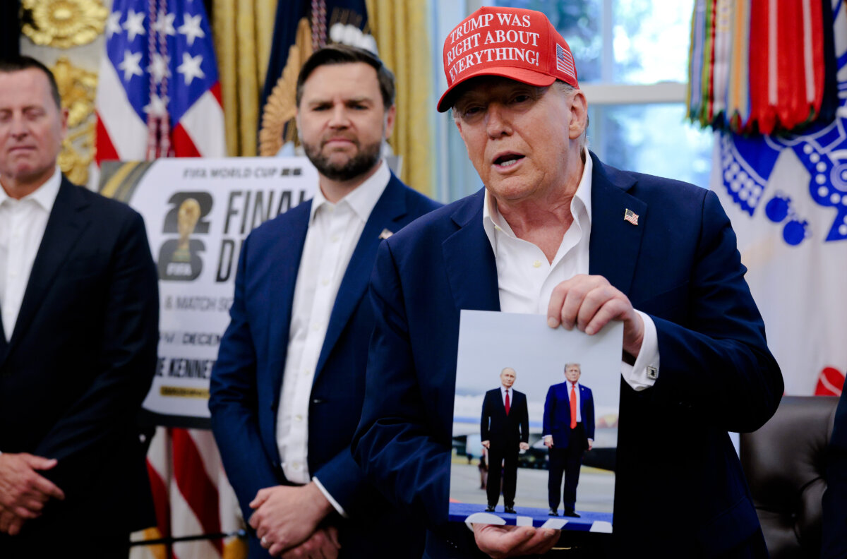 President Donald Trump holds a photograph he said was given to him as a gift by Russian President Vladimir Putin in the Oval Office at the White House in Washington, on Aug. 22, 2025. (Chip Somodevilla/Getty Images)