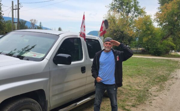 UOF supporter Ron Wilkison salutes in front of his truck, Aug. 27 at Universal Ostrich Farms in Edgewood, B.C. on Aug. 27, 2025. (Paul Rowan Brian / The Epoch Times).