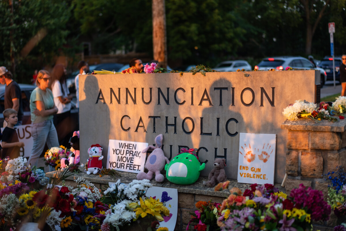 People leave flowers as they mourn in the aftermath of the Annunciation Catholic School shooting in Minneapolis, on Aug. 28, 2025. (Madalina Kilroy /The Epoch Times)