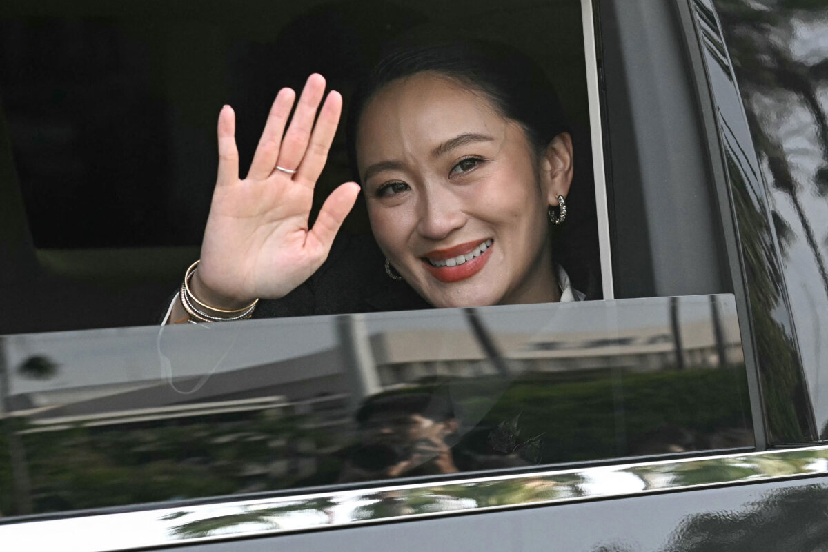 Paetongtarn Shinawatra waves from a car as she leaves Government House after being dismissed from the position of prime minister by the Constitutional Court in Bangkok on Aug. 29, 2025. (Lillian Sunwanrumpha/AFP)