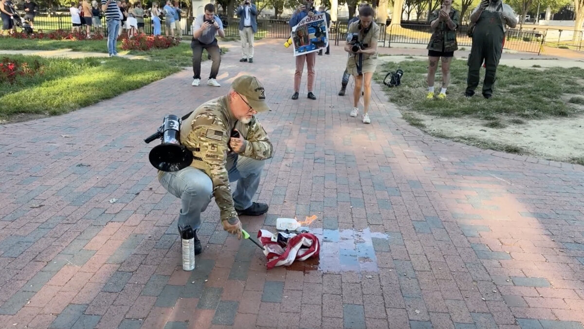 A man burns a U.S. flag outside the White House on Aug. 25, 2025. (CNN)