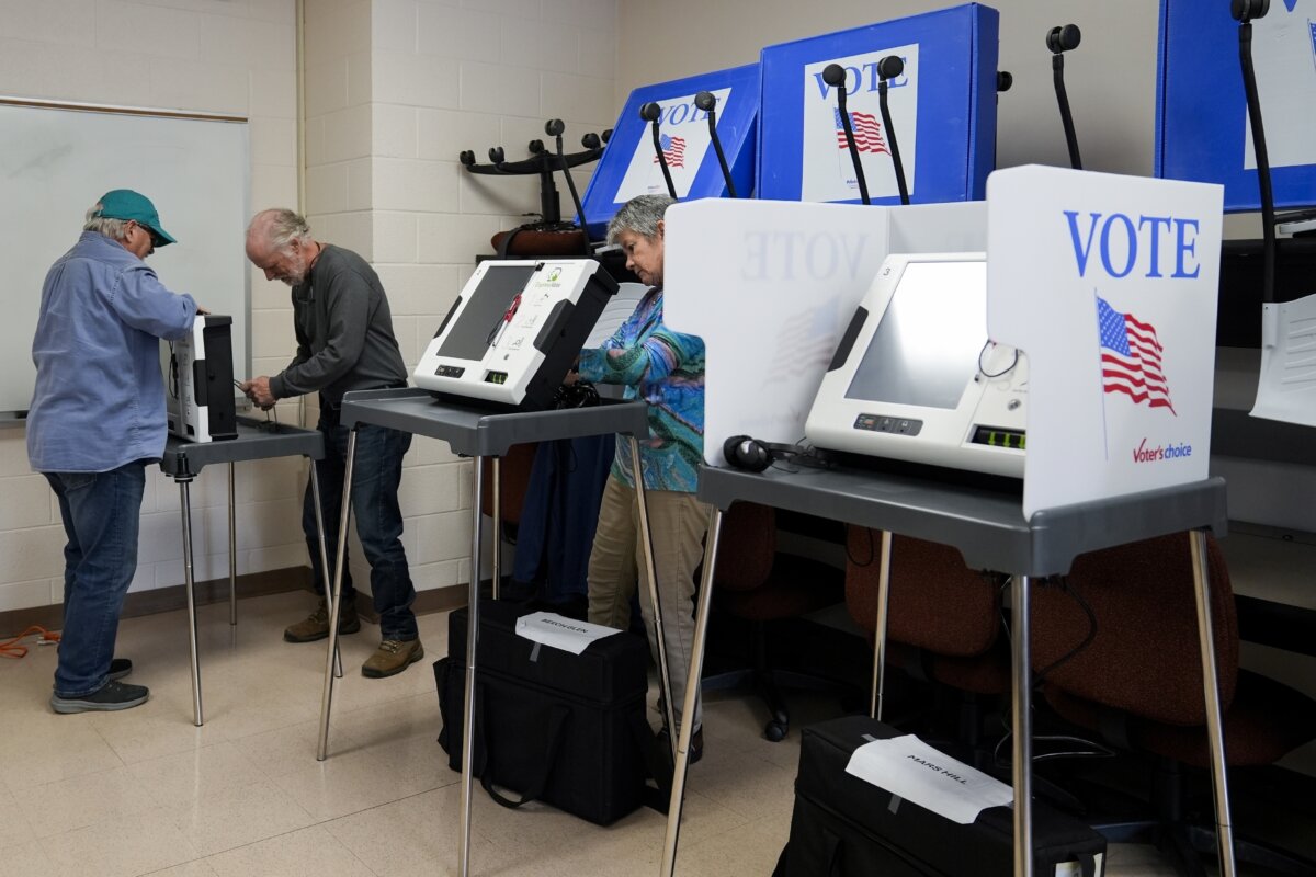 FILE - Poll workers set up ballot-marking machines at an early in-person voting site at Asheville-Buncombe Technical Community College in Marshall, N.C., on Oct. 16, 2024. (AP Photo/Stephanie Scarbrough,File)