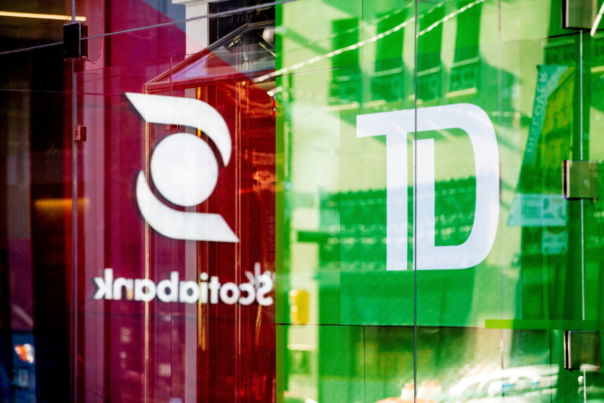 A sign for The Bank of Nova Scotia, operating as Scotiabank, is seen in a reflection besides a sign for TD Canada Trust in Toronto, Dec. 13, 2021. (Reuters/Carlos Osorio)