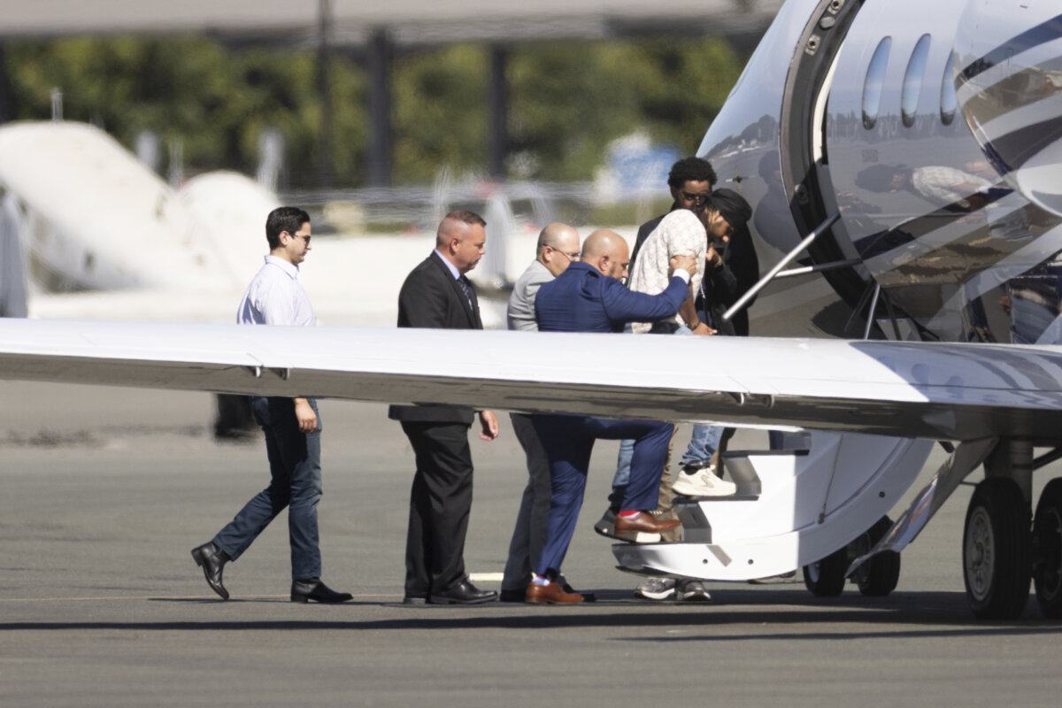 Harjinder Singh is escorted onto an airplane by Florida Lt. Gov. Jay Collins and law enforcement in Stockton, Calif., on Aug. 21, 2025. (AP Photo/Benjamin Fanjoy)