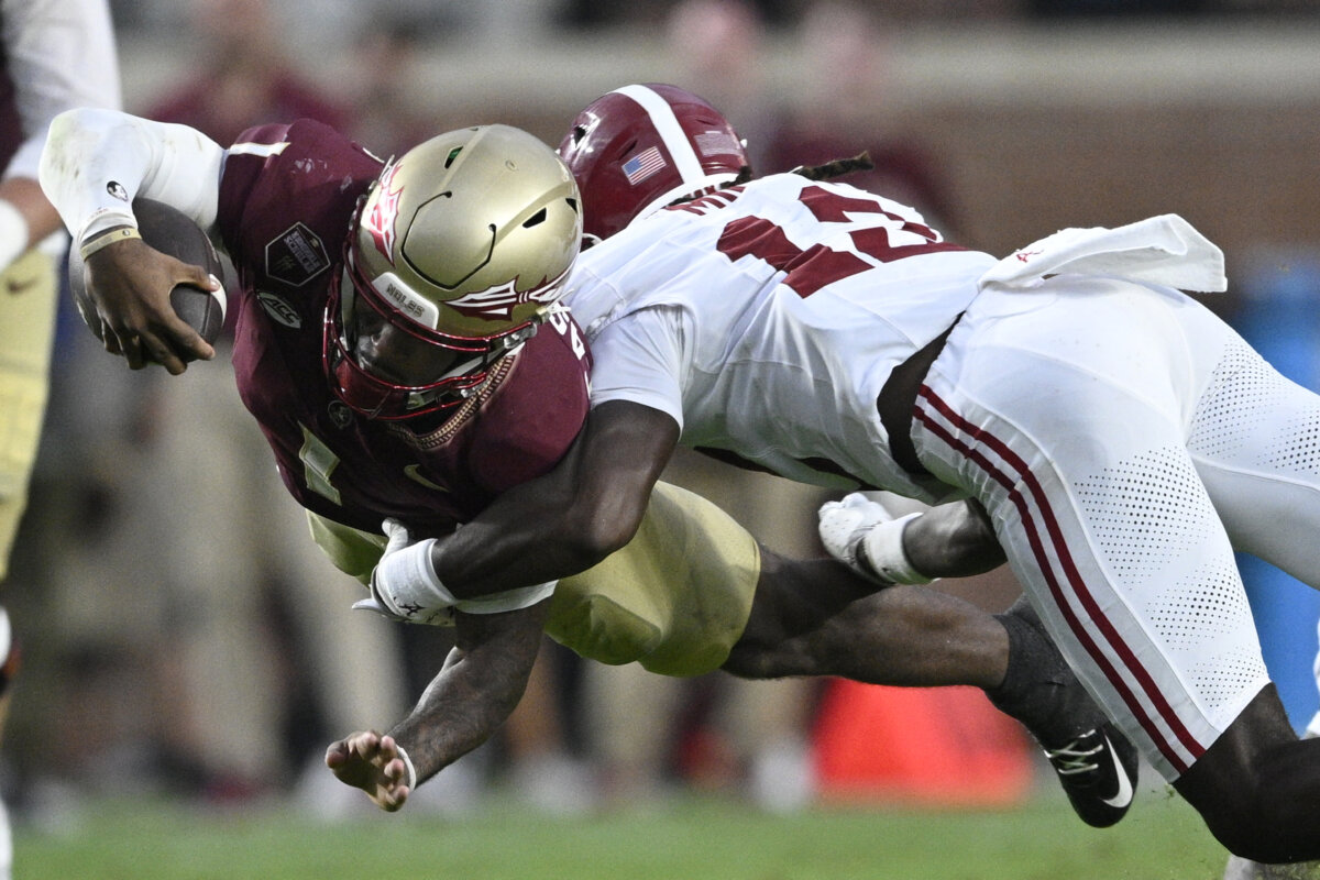 Florida State quarterback Tommy Castellanos (1) dives for extra yardage as Alabama defensive back Zavier Mincey (12) makes the tackle during the second half of an NCAA college football game on Aug. 30, 2025, in Tallahassee, Fla. (Phelan M. Ebenhack/AP Photo)