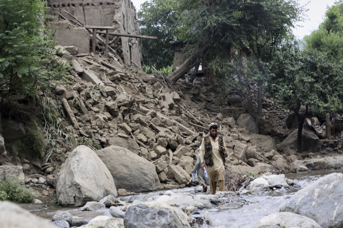 A man and a boy cross a stream of water next to a house destroyed by an earthquake that killed many people and destroyed villages in eastern Afghanistan, in Mazar Dara, Kunar province, Afghanistan, on Sept. 1, 2025. (Wahidullah Kakar/AP Photo)