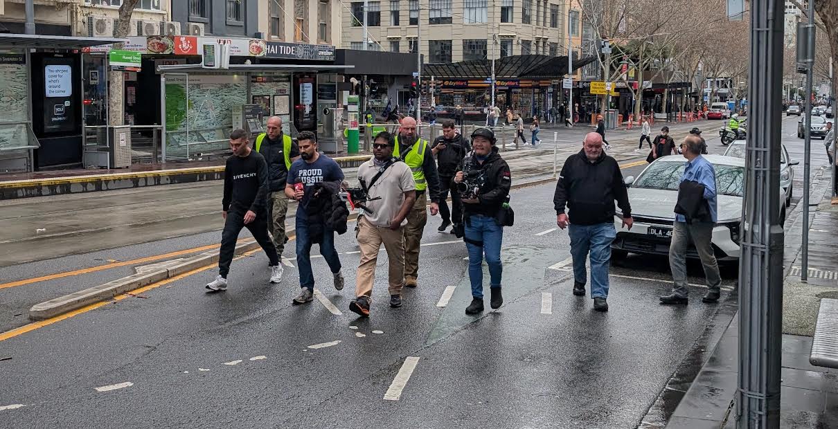 Security guard Daniel Jones (in security vest) has brushed off suggestions he could now be a target for neo Nazis at future rallies. Picture: Josh Spasaro.