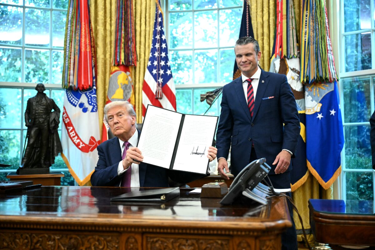 President Donald Trump (L) shows a signed executive order next to the Secretary of Defense Pete Hegseth in the Oval Office of the White House on Sept. 5, 2025. (Mandel Ngan/AFP via Getty Images)