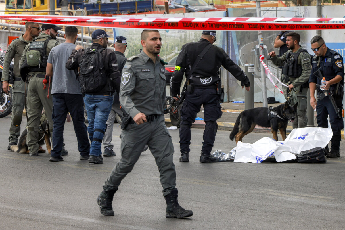 Israeli security forces gather by a body next to a bus at Ramot Junction in Jerusalem on Sept. 8, 2025. (Menahem Kahana/AFP via Getty Images)
