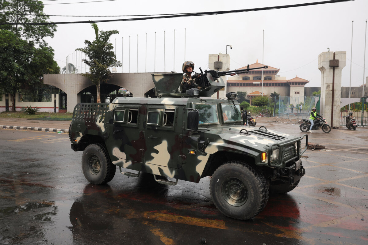A Nepali army solider stands in an armored vehicle driving past the Parliament house, which was set on fire by protesters in Kathmandu, Nepal, on Sept. 10, 2025. (Adnan Abidi/Reuters)