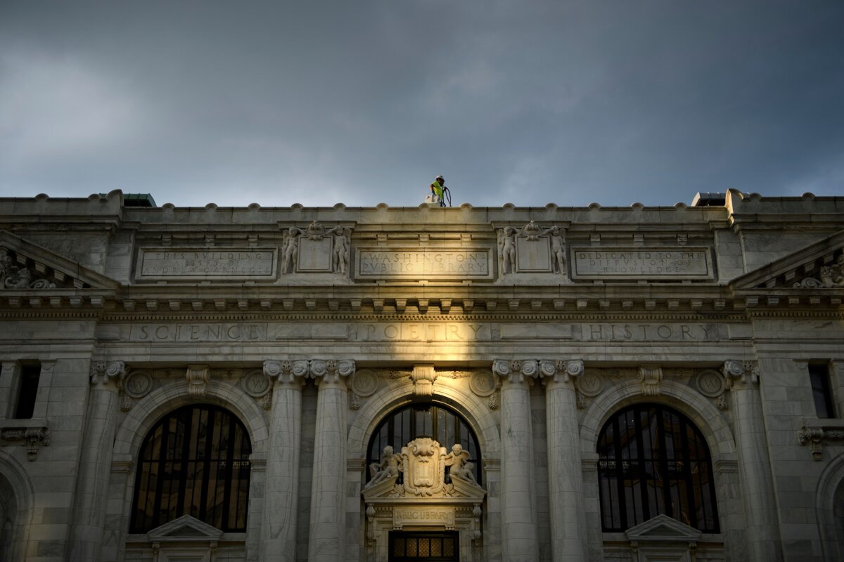 A worker walks on the roof of the Carnegie Library as it is converted to an Apple Store in Washington on April 30, 2019. (Brendan Smialowski/AFP/Getty Images)