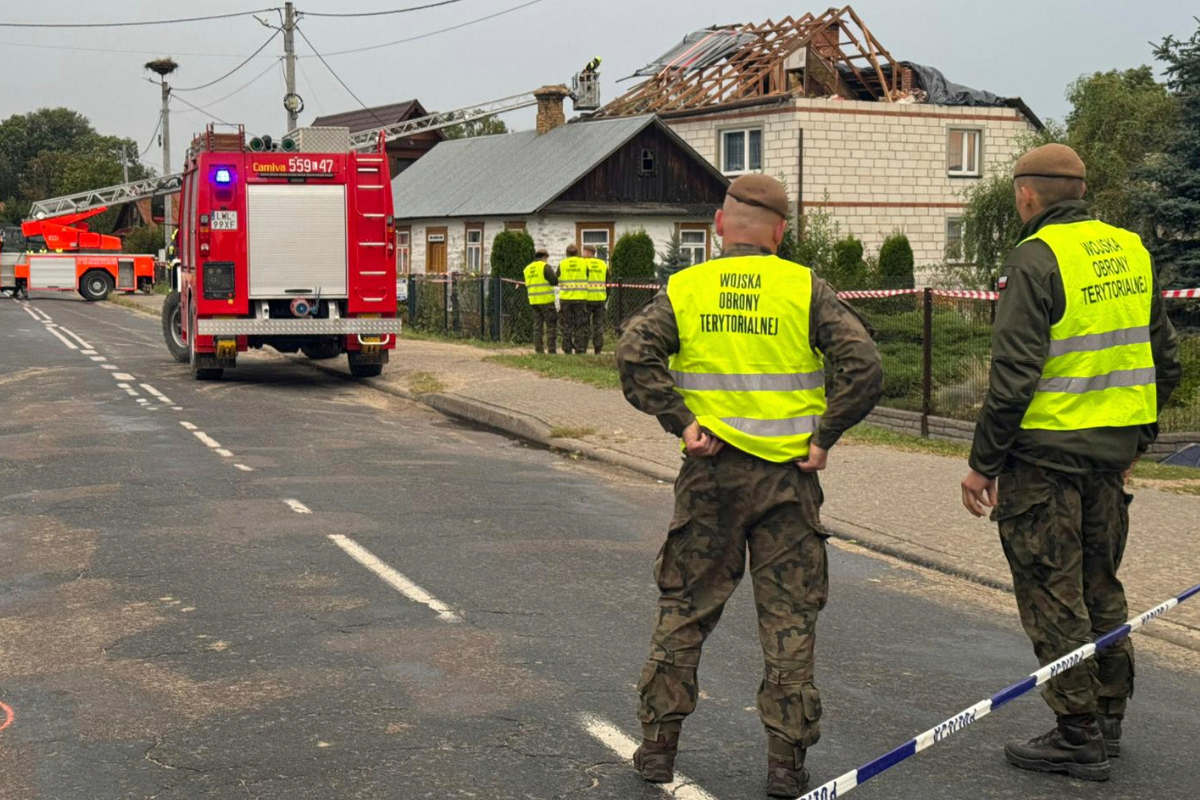 Firefighters and territorial defense officers stand close to the destroyed roof of a house, after suspected Russian drones violated Polish airspace during an attack on Ukraine, in Wyryki near Lublin, Poland, on Sept. 11, 2025. (Rafal Niedzielski/AP Photo)