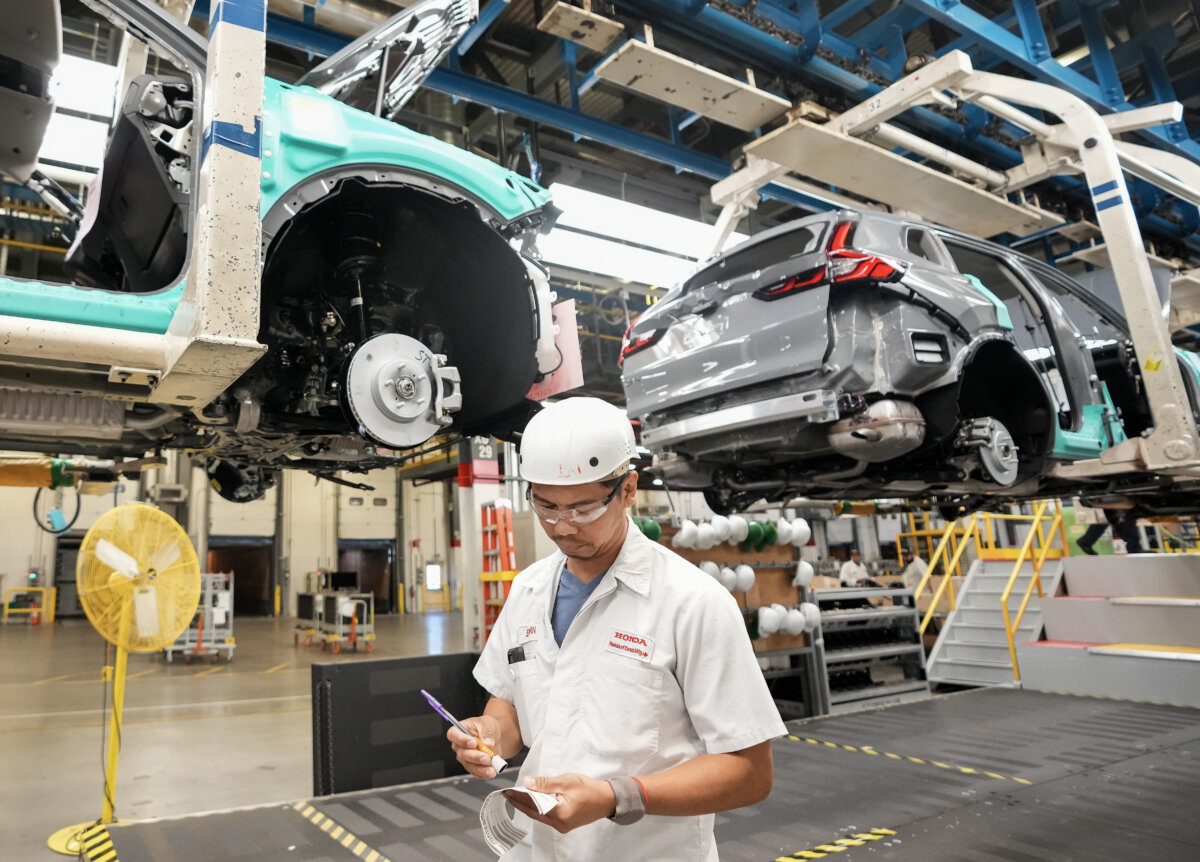 Honda employees work along the vehicle assembly line before an event announcing plans for a Honda electric vehicle battery plant in Alliston, Ont., on April 25, 2024. (The Canadian Press/Nathan Denette)