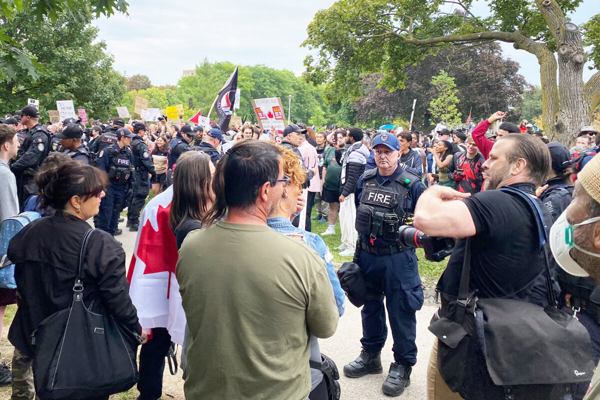 Police and fire department officers separate an anti-immigration protest from a counter-protest in Christie Pits Park in Toronto on Sept. 13, 2025. (The Canadian Press/Vanessa Tiberio)