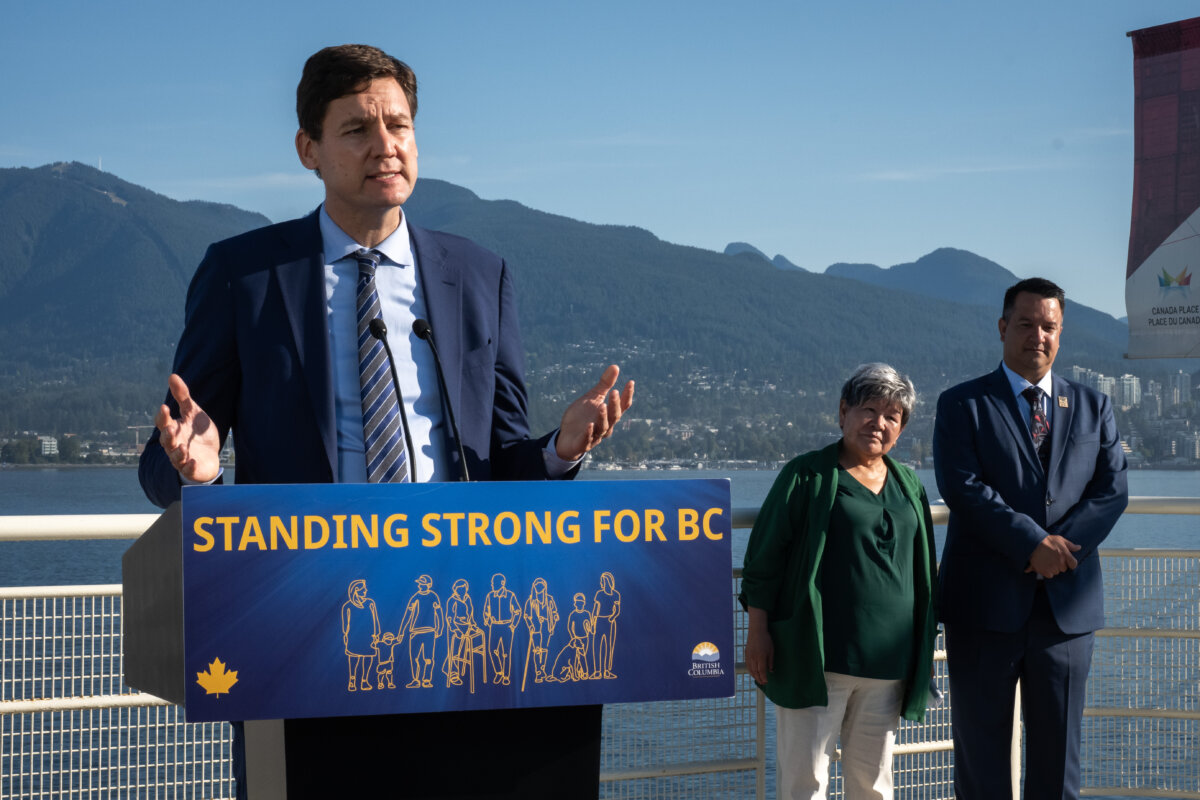 B.C. Premier David Eby speaks as Nisga'a Nation President, Eva Clayton and Nisga'a CEO, Andrew Robinson listen during a Ksi Lisims LNG announcement of an environmental assessment certificate from the Government of British Columbia in Vancouver, on Sept. 16, 2025. (THE CANADIAN PRESS/Ethan Cairns)